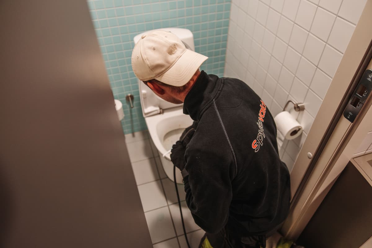 Bilde av operatør fra Spylevakta som arbeider med tett toalett