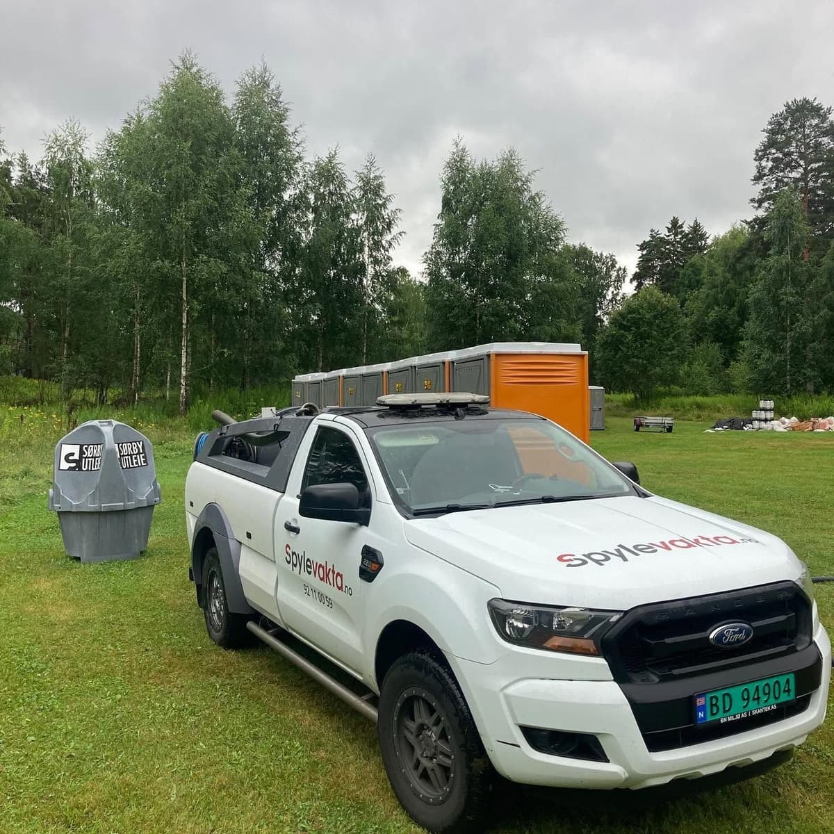 Spylevakta sin servicebil ved utleietoaletter og mobile urinaler på et festivalområde