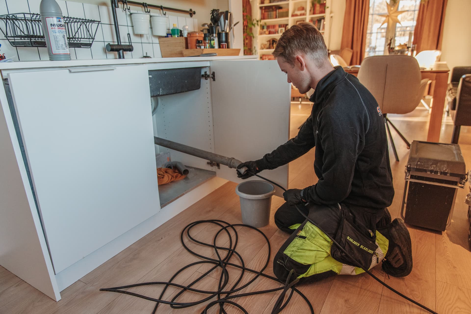 Bilde av operatør fra Spylevakta som spyler tette rør på kjøkken